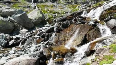 瀑布在田园诗般的无<strong>污染环境</strong>中流动，夏天穿过阿尔卑斯山上的绿色草地和巨石。